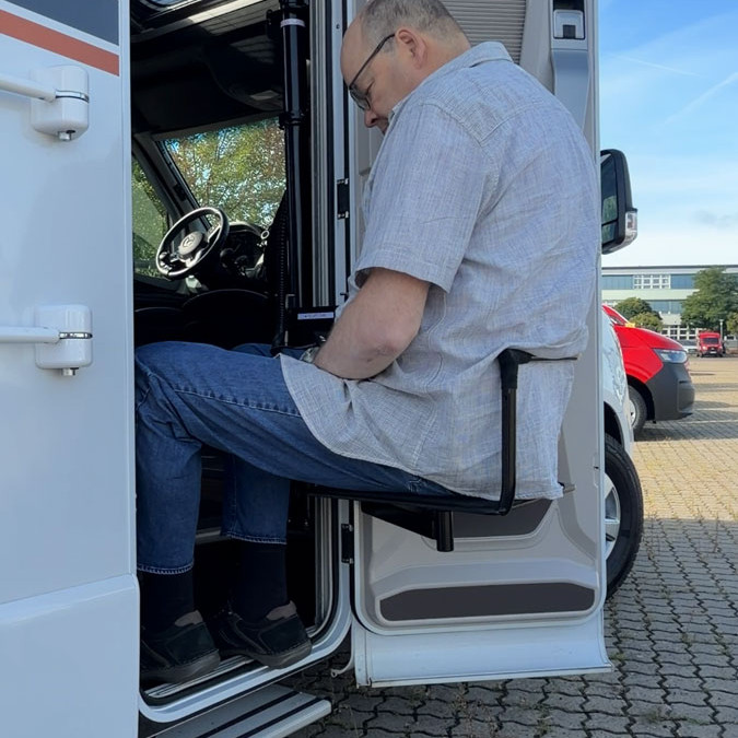 Person steigt mit Hilfe des RV Lifts aus dem Wohnmobil aus