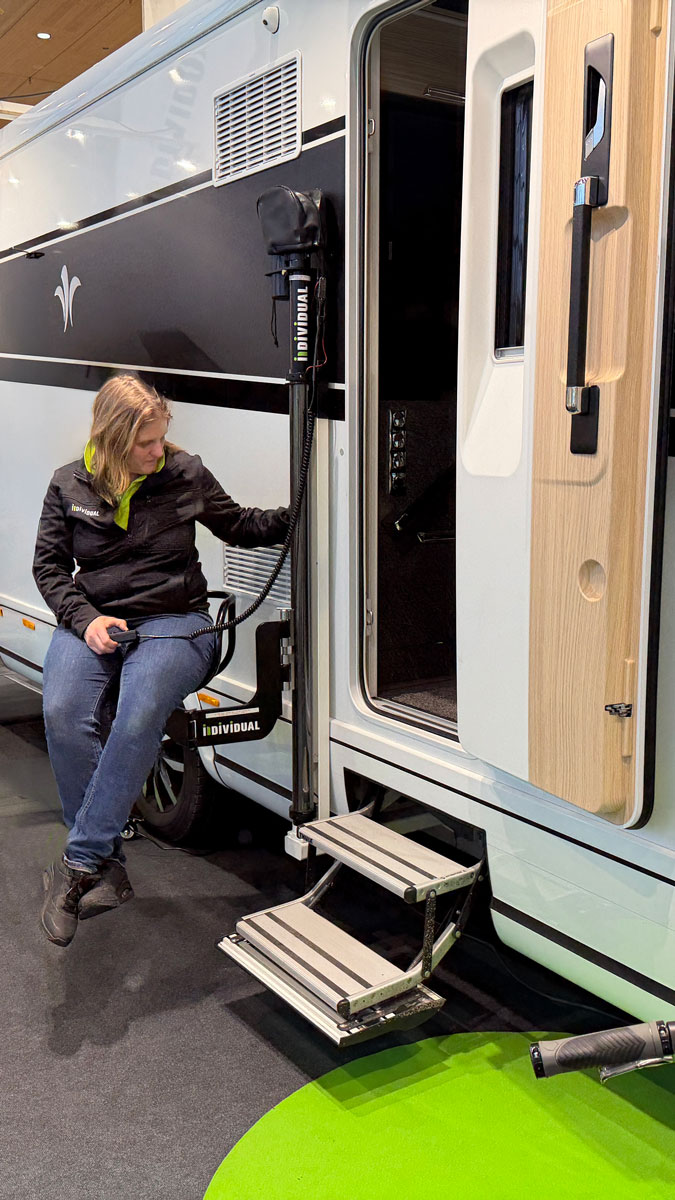 Person sitz auf dem Sitzbrett des RV Lifts und demonstriert die Funktionsweise