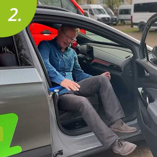 Mann stützt sich auf einen Griff ab, um aus dem Fahrzeug zu gelangen