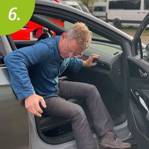 Mann stützt sich auf einen Griff ab, um aus dem Fahrzeug zu gelangen