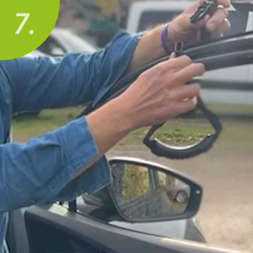 Mann hängt Haltegriff an die Tür eines Autos